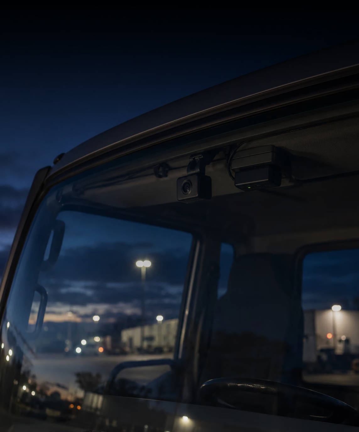 Photograph: an installed camera and telematics unit, close and quiet. Dark and cool, room at the top, no text in the artwork.