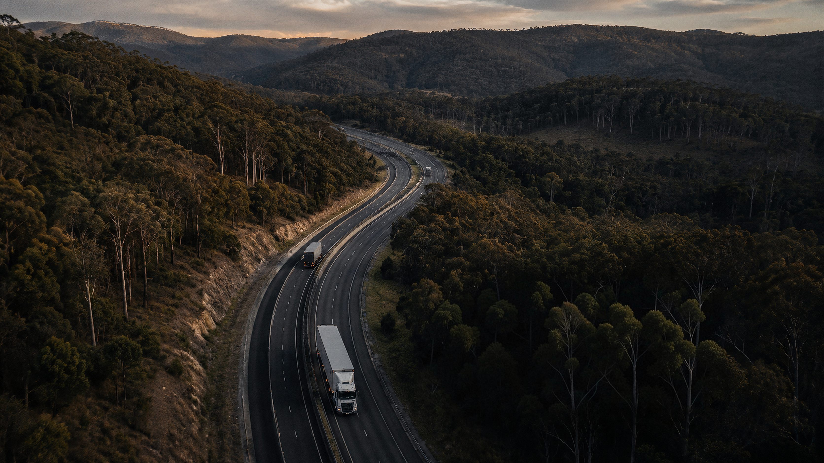 Aerial view of a highway carrying freight through forested hills
