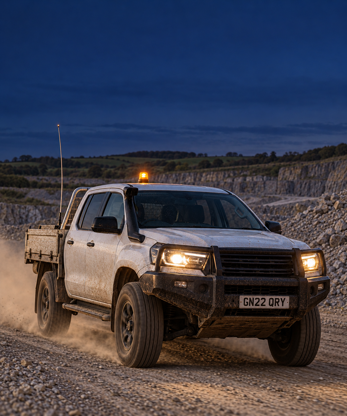 Photograph: a light vehicle on a haul road at first light. Dark and cool, room at the top, no text in the artwork.