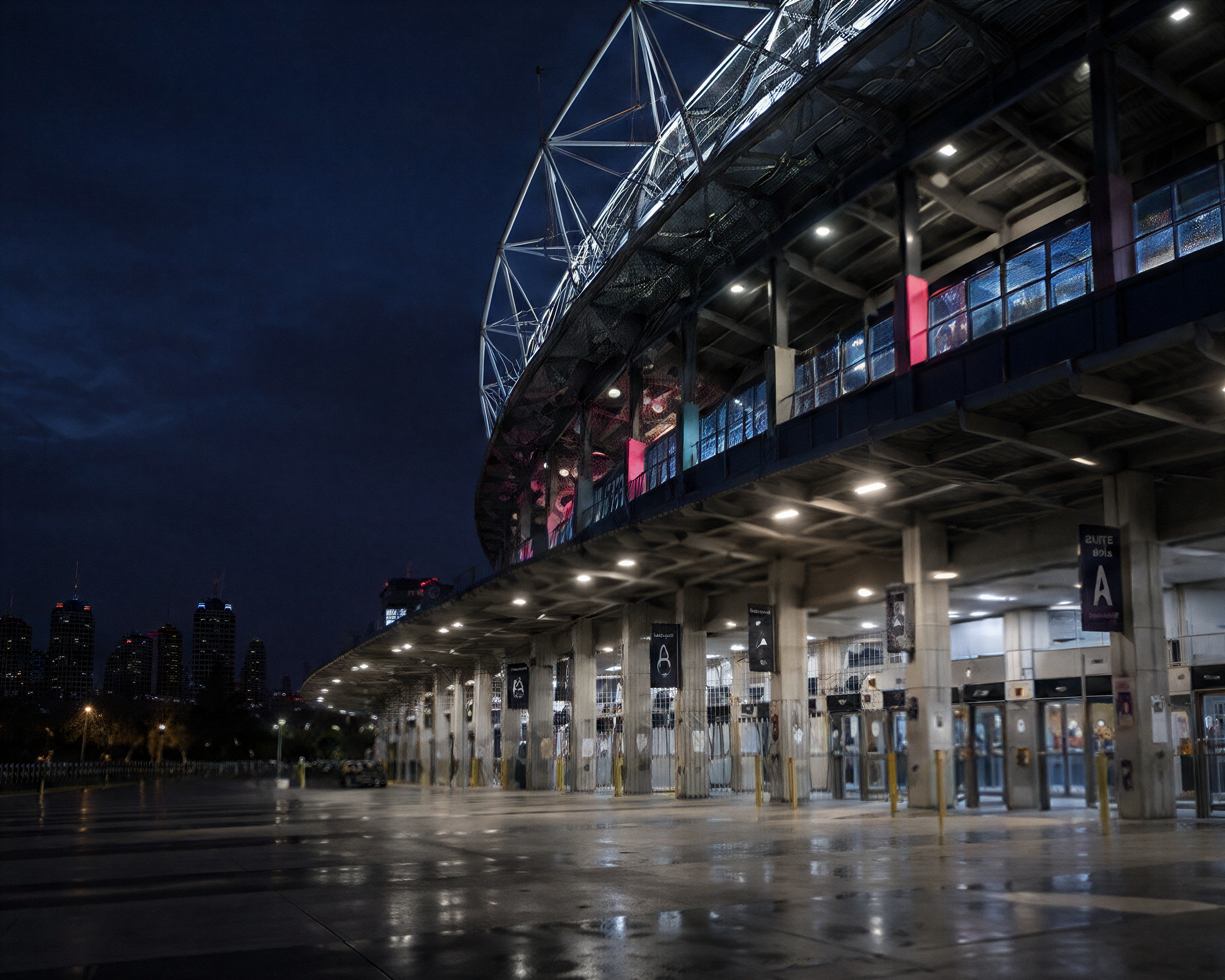 Photograph: a stadium concourse before doors, lit and empty. Dark and cool, no text in the artwork.