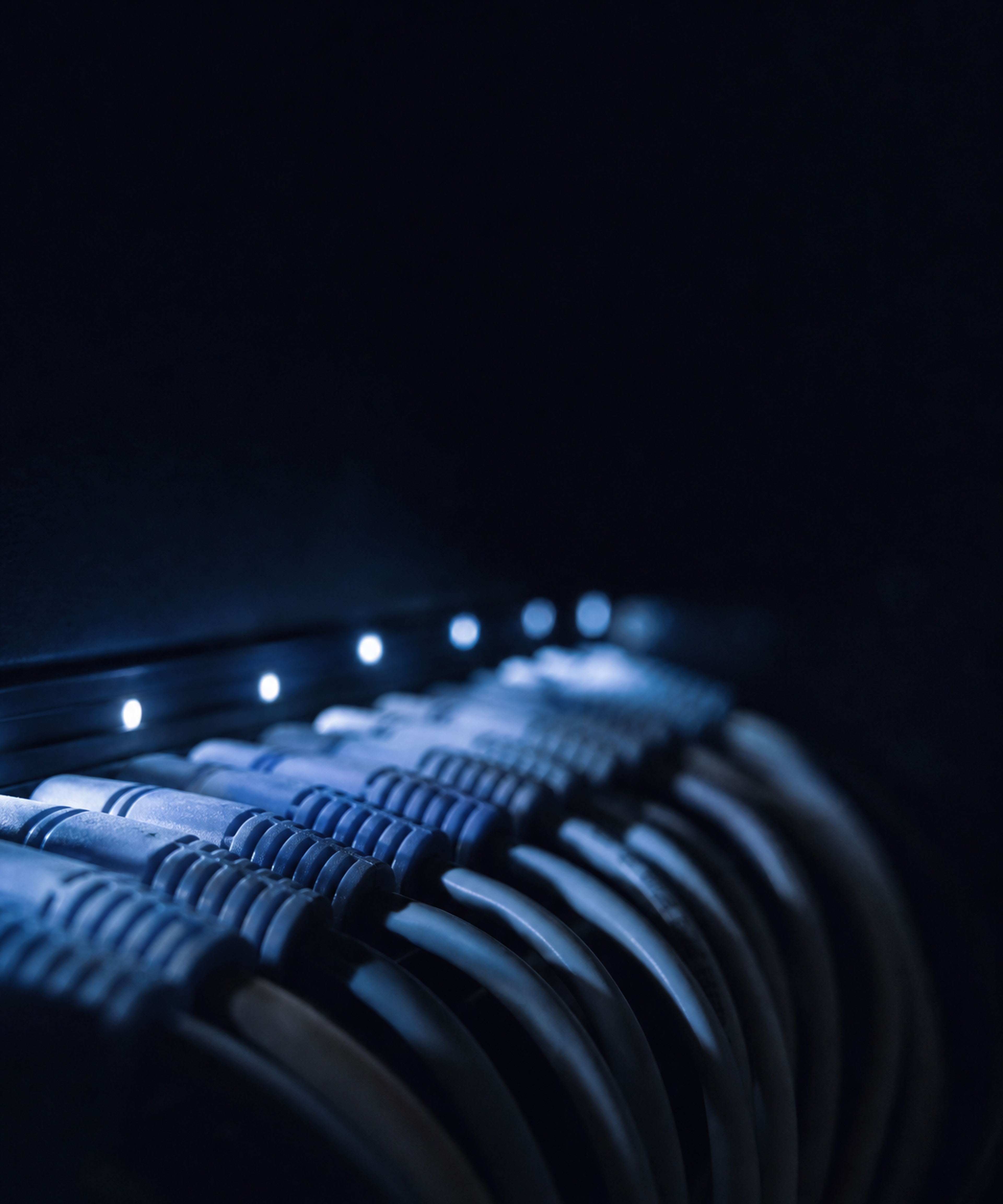 Photograph: an abstract close detail of a server rack or cabling, cool and dark. Room at the top, no text in the artwork.