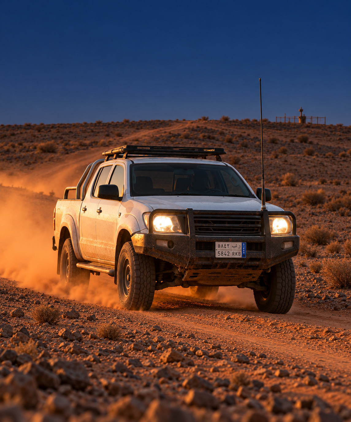 Photograph: a light vehicle on a remote access road at first light. Dark and cool, room at the top, no badges or text in the artwork.