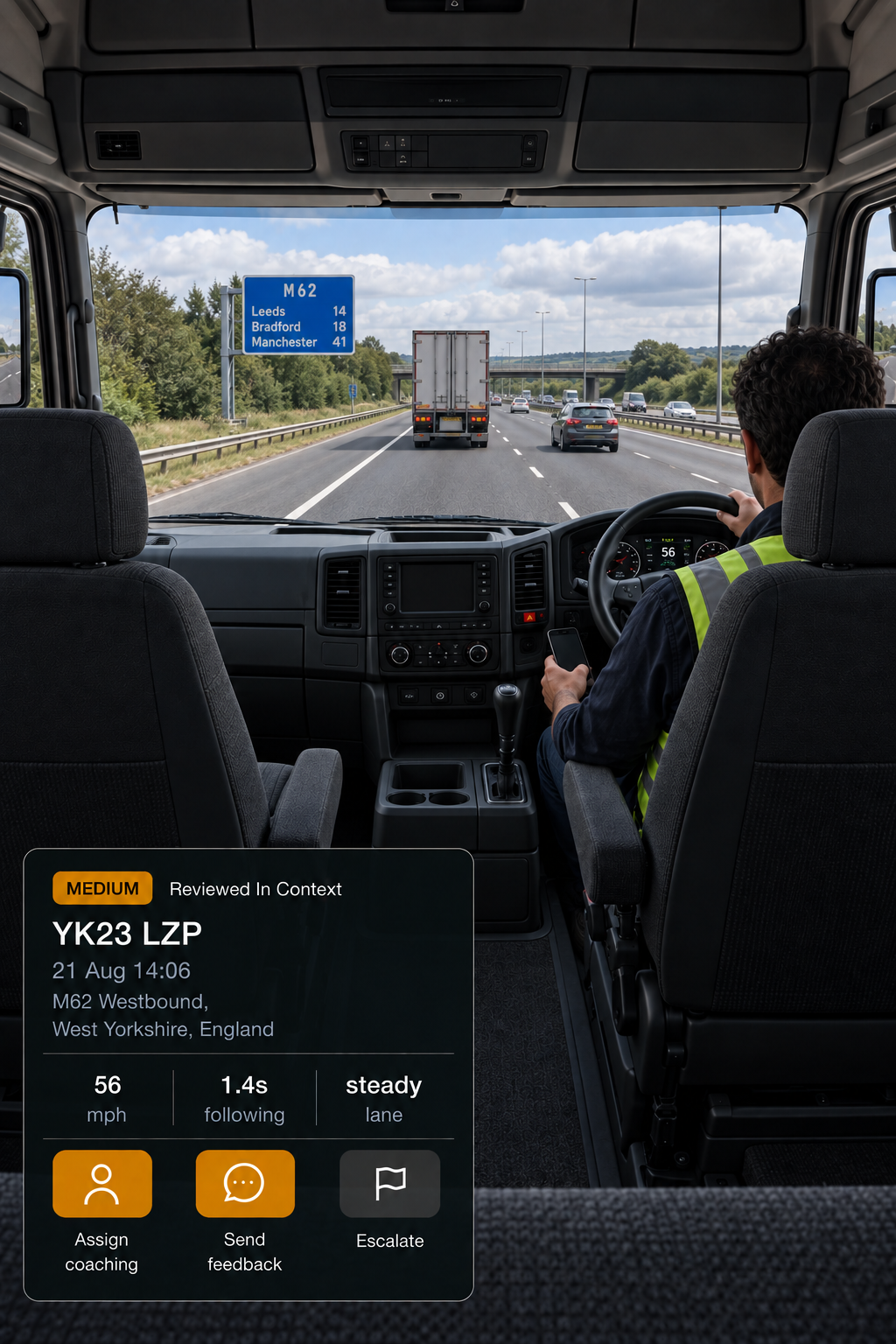 Photograph: a manager at a desk reviewing in-cab footage on a monitor, screen content not legible. Portrait 3:4, dark and cool, room at the top for a heading, no text in the artwork.