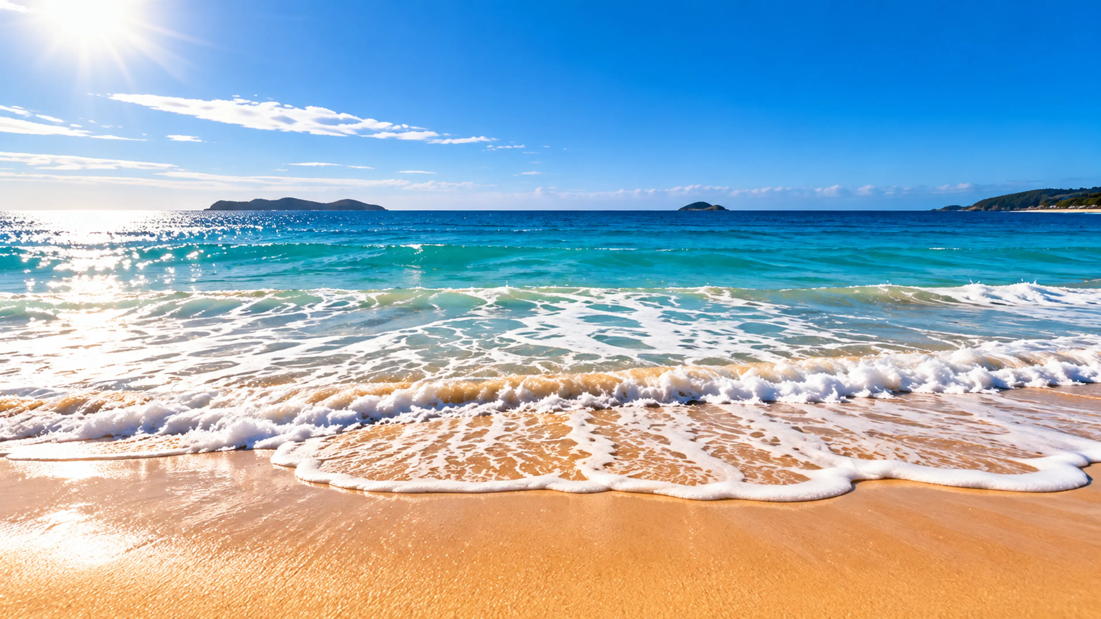 Waves rolling onto a sunlit Australian beach under a clear summer sky