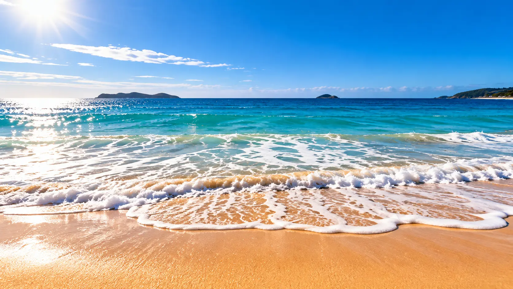Waves rolling onto a sunlit Australian beach under a clear summer sky